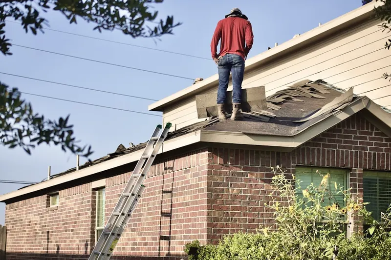 Professional roofer working on a residential roof in Tabor